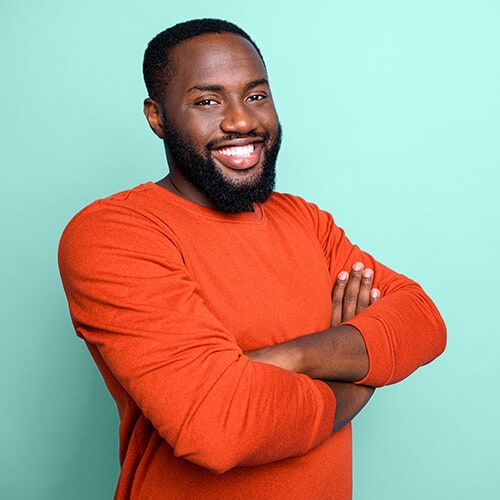 African American man in orange sweater on blue background
