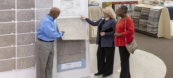 NFM saleswoman showing carpet options to customers